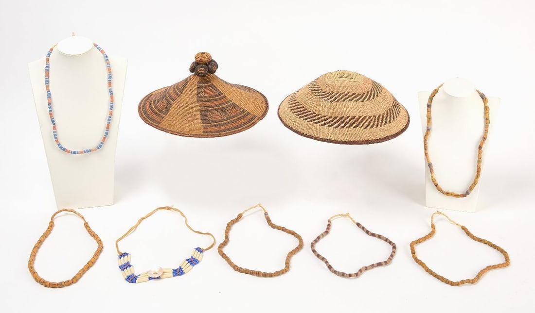 Native American Grouping: Northwest Coast Native group of coiled basket, hat, and seven nacklaces. 19th - 20th century. Basket: H 4 in. D 12 in. Hat: H 5-1/2 in. D 12 in. Necklaces: D 13 in.