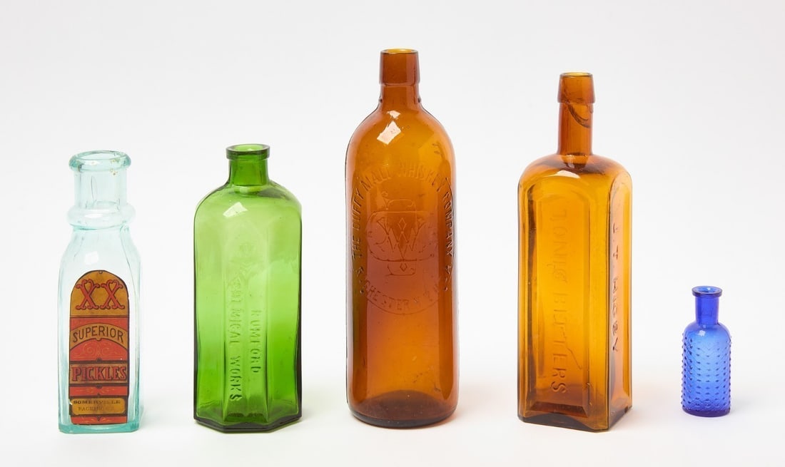 Group of Glass Bottles with Quilted Poison: Group of 5 glass bottles which includes a cobalt blue quilted poison. Others are Superior Pickles with paper label, Rumford Chemical Works, JT Higby Tonic Bitters (amber), and Duffy Malt Whisky