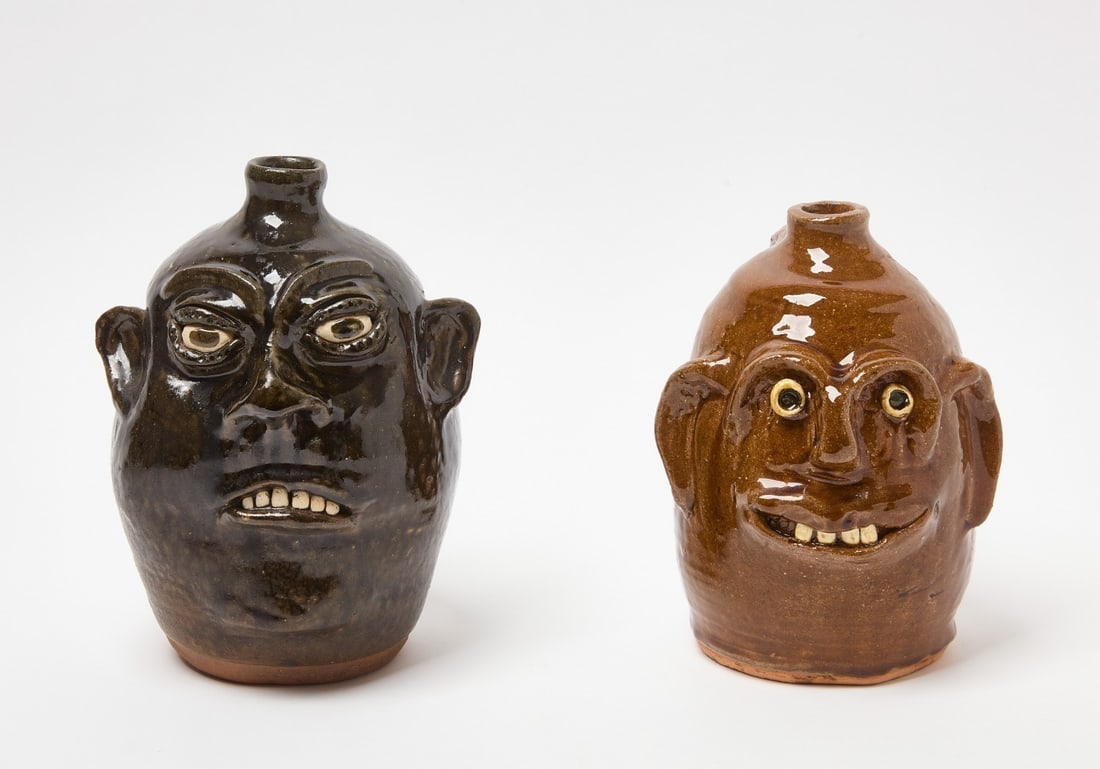 Two Meaders Face Jugs: Two Meaders family face jugs. One in brown glaze signed behind right ear 'Reggie Meaders'. Together with a jug in black glaze signed underneath 'Cleater and Bill 1990'. H 8-3/4