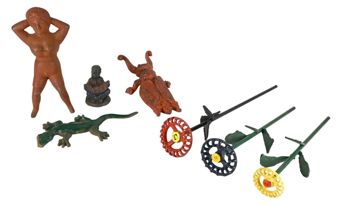 Group of Folk Cast Iron and Metal Novelty Objects: Group of folk cast metal objects, seven items total. Comprising a nude figural sculpture; a seated figure eating watermelon; a beetle-form figure; a lizard; and three folk art whirligig-style flower