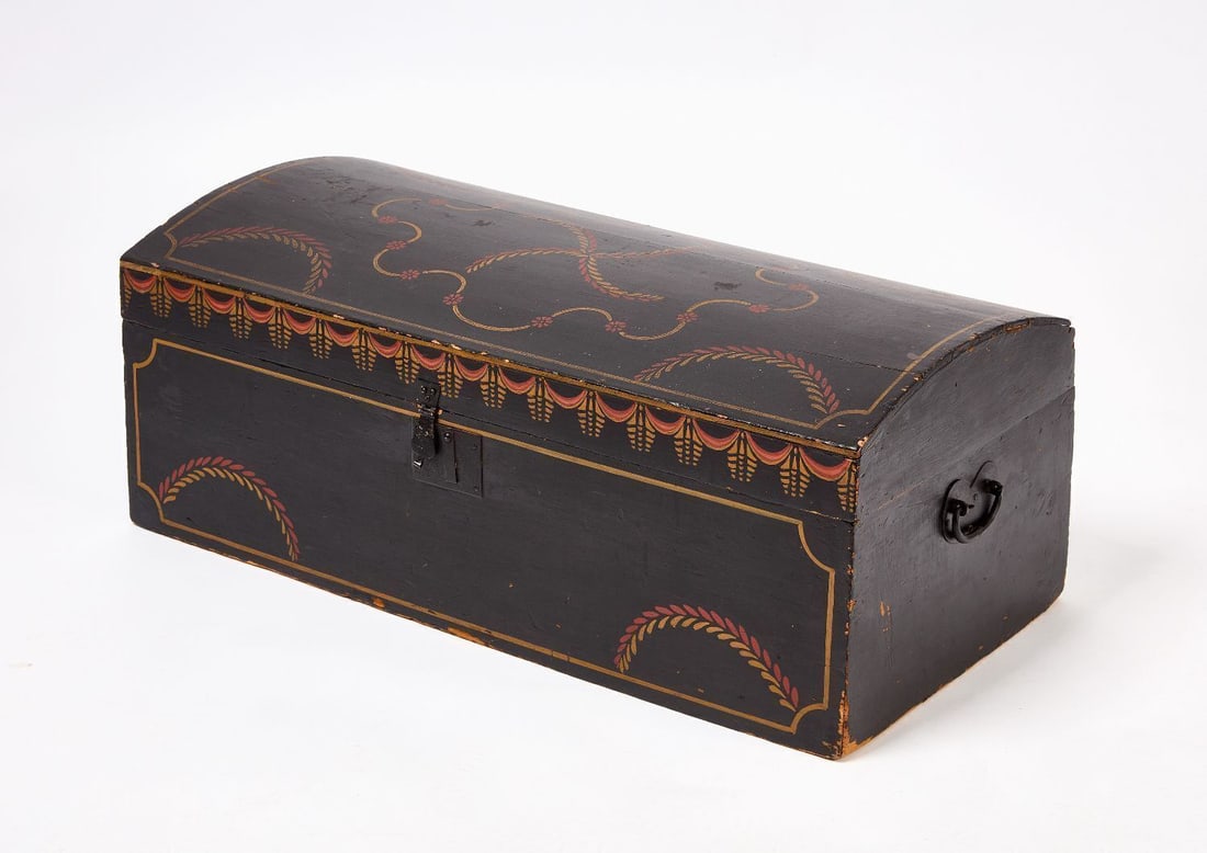 Paint Decorated Trunk: Dome-top trunk with swag and tassle paint decoration. Old black painted ground with polychrome swag and tassel decoration to lid. Sturbridge, Mass., early 19th century. H 12-1/2 in. W 32 in. D 15