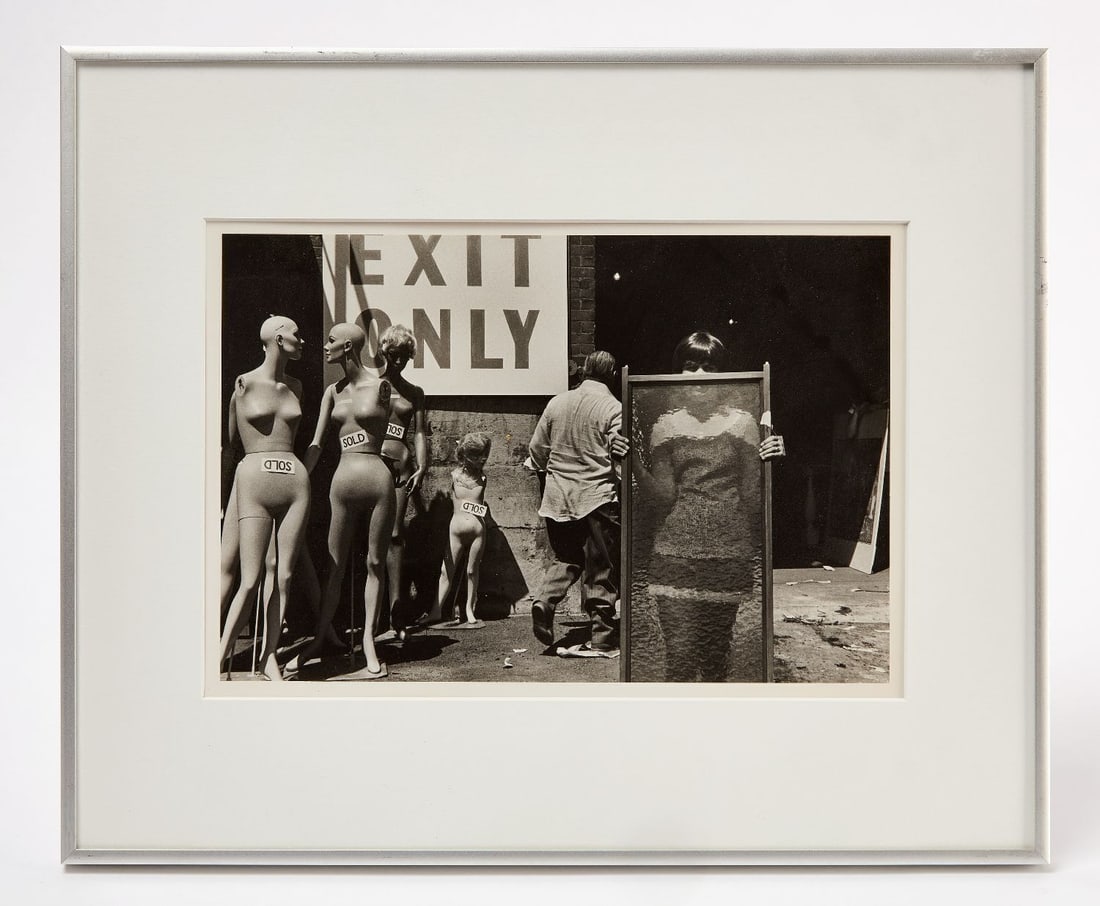 John Lester Raye - Hartford: John Lester Raye (Connecticut, b. 1952) - 'Hartford'. Photograph depicting a woman holding a translucent screen with some 'SOLD' mannequins outside a building, in original frame.
