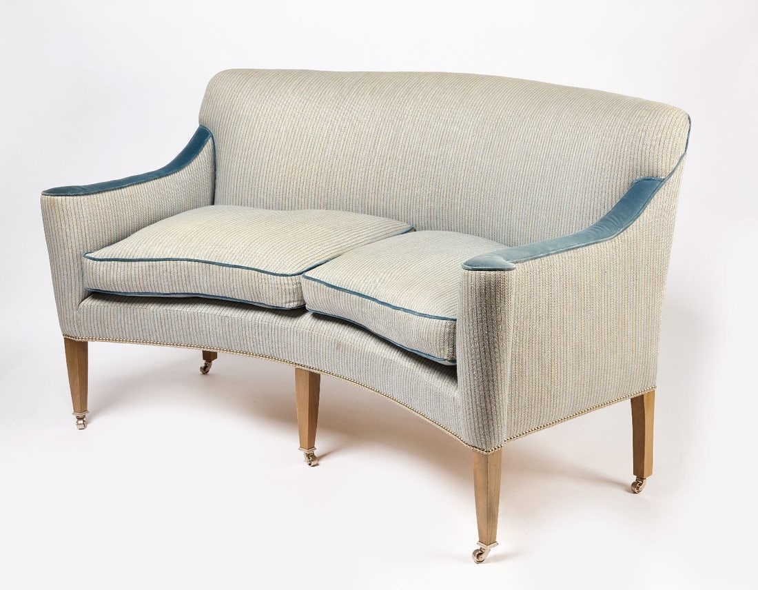 William Yeoward Curve-Back Settee: William Yeoward curve-back settee. Down filled with wool blend upholstery with velvet piping. Castor wheels on each leg. H 38-1/4 in. W 66 in. D 36 in.