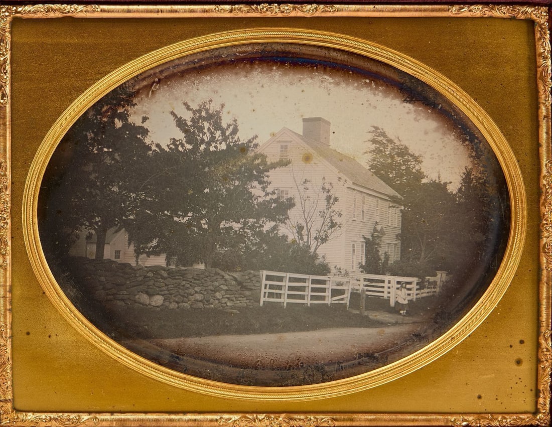Whole Plate Daguerreotype of a House: Whole plate daguerreotype of a house shown from the street, with a rock wall and fence in front, and trees surrounding. A little girl stands out front. Under glass, mat, and preserver. Housed in