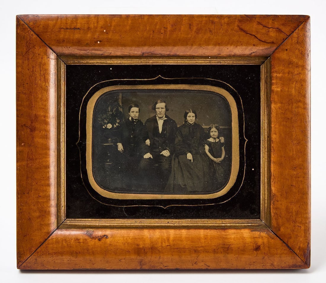 Whole Plate Ambrotype of a Family Group: Whole plate clear glass ambrotype photograph of a family group. Period maple frame. Family info taped to backside of frame. American, circa 1850. Frame: H 10-1/2 in. W 12 in. Plate: H 6-1/2 in. W 8-1/
