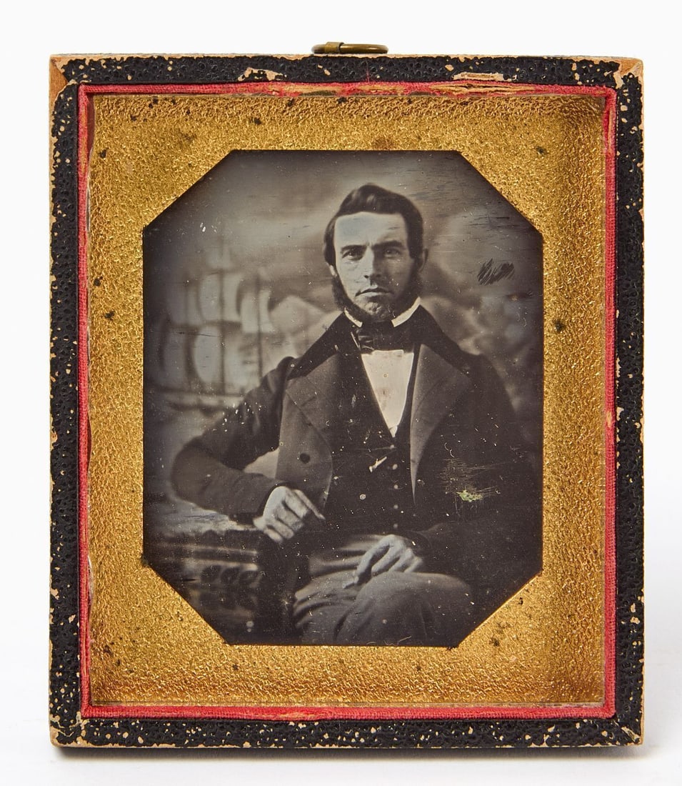 Daguerreotype Portrait of a Ship Captain: Sixth plate Daguerreotype of a ship or whaling captain. Photographed with nautical studio backdrop. Early octagonal pebbled mat, and glass. In a half case. New England, circa 1845. Case: H 3-5/8 in. W