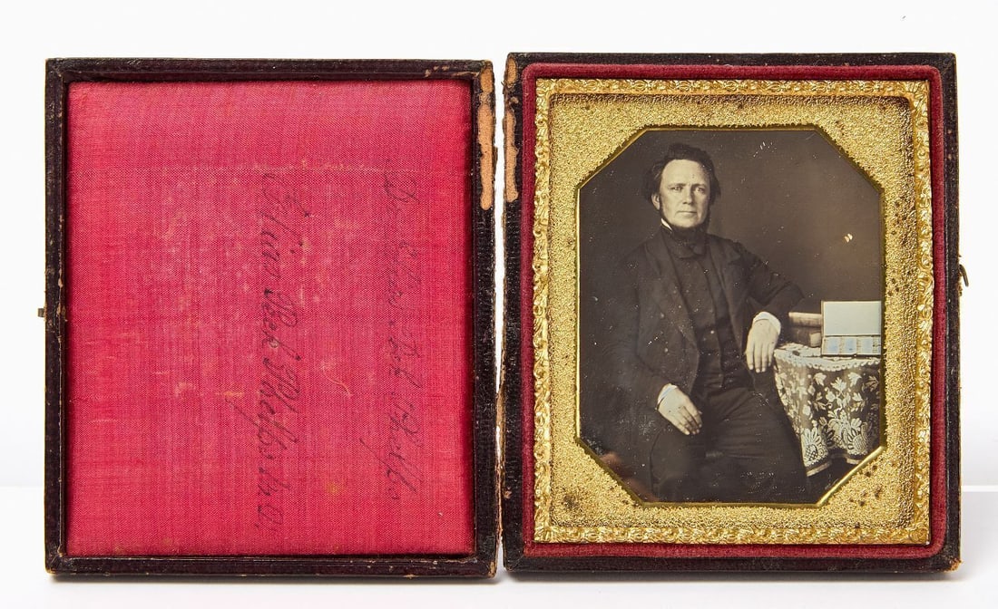 Daguerreotype Portrait of Dr. Elias Peck Phelps: 1/6 plate daguerreotype portrait of Dr. Elias Peck Phelps. Shown seated, and presenting a small cased set of surgical tools propped up against two books on the table next to him. Under pebbled octagon