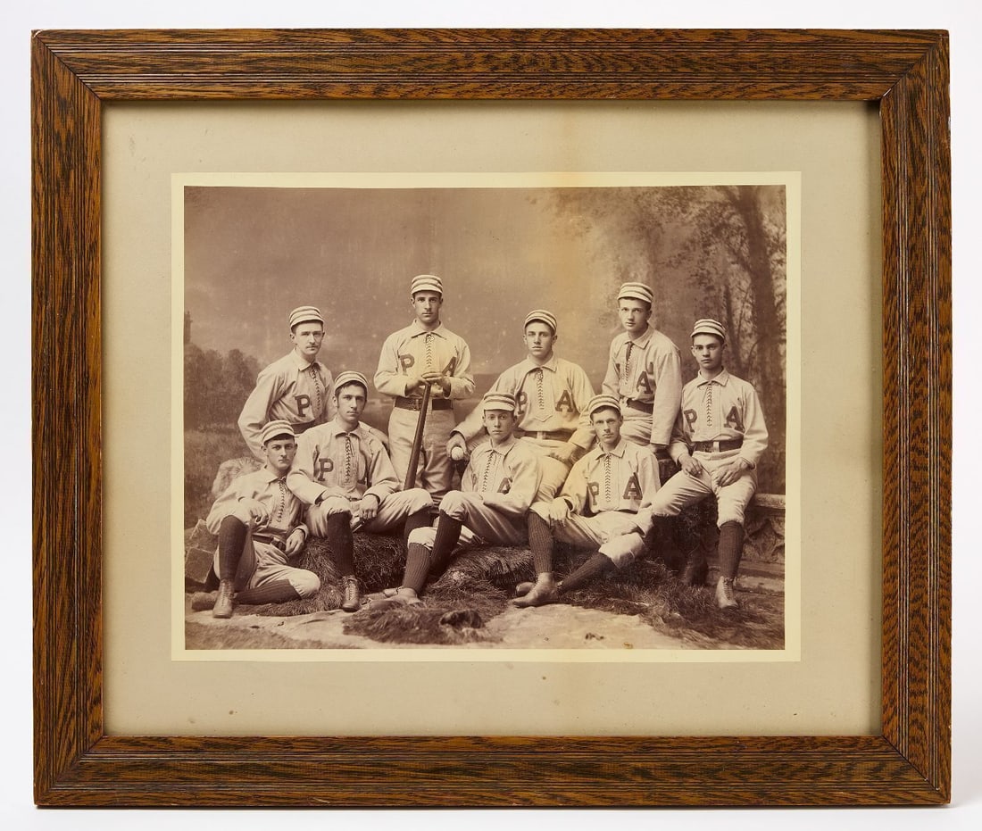 Early Albumen Photograph of a Baseball Team: Early large format albumen photograph of a baseball team. Shown in a photo studio, the 9-member team is wearing full uniforms with shirts bearing the initials 'PA', possible for Phillips
