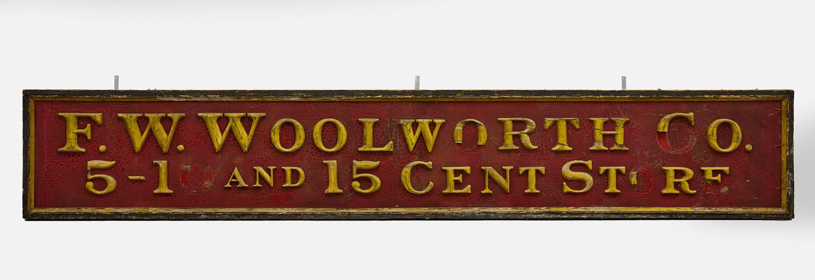Early FW Woolworth Co Trade Sign: FW Woolworth Co trade sign. Single-sided wood with original red painted background and gilt painted applied wooden letters. New York, 19th century. H 20-1/4 in. W 120 in.
