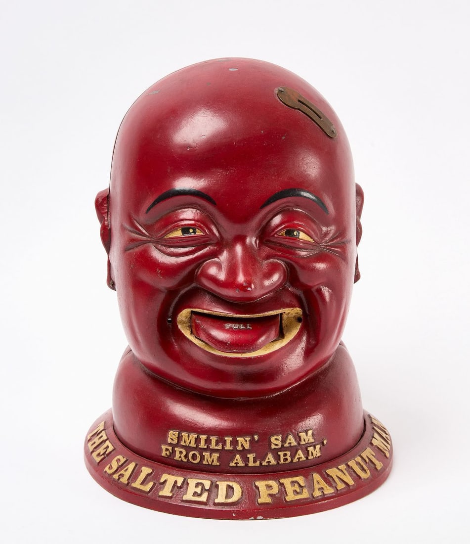Smilin Sam Coin-Op Peanut Vendor Machine: Penny (1 cent) Coin-Operated Peanut Vendor, "Smilin' Sam from Alabam" The Salted Peanut Man. Cast aluminum. Embossed underneath base General Merchandiser Inc.-Chicago, circa 1930. H