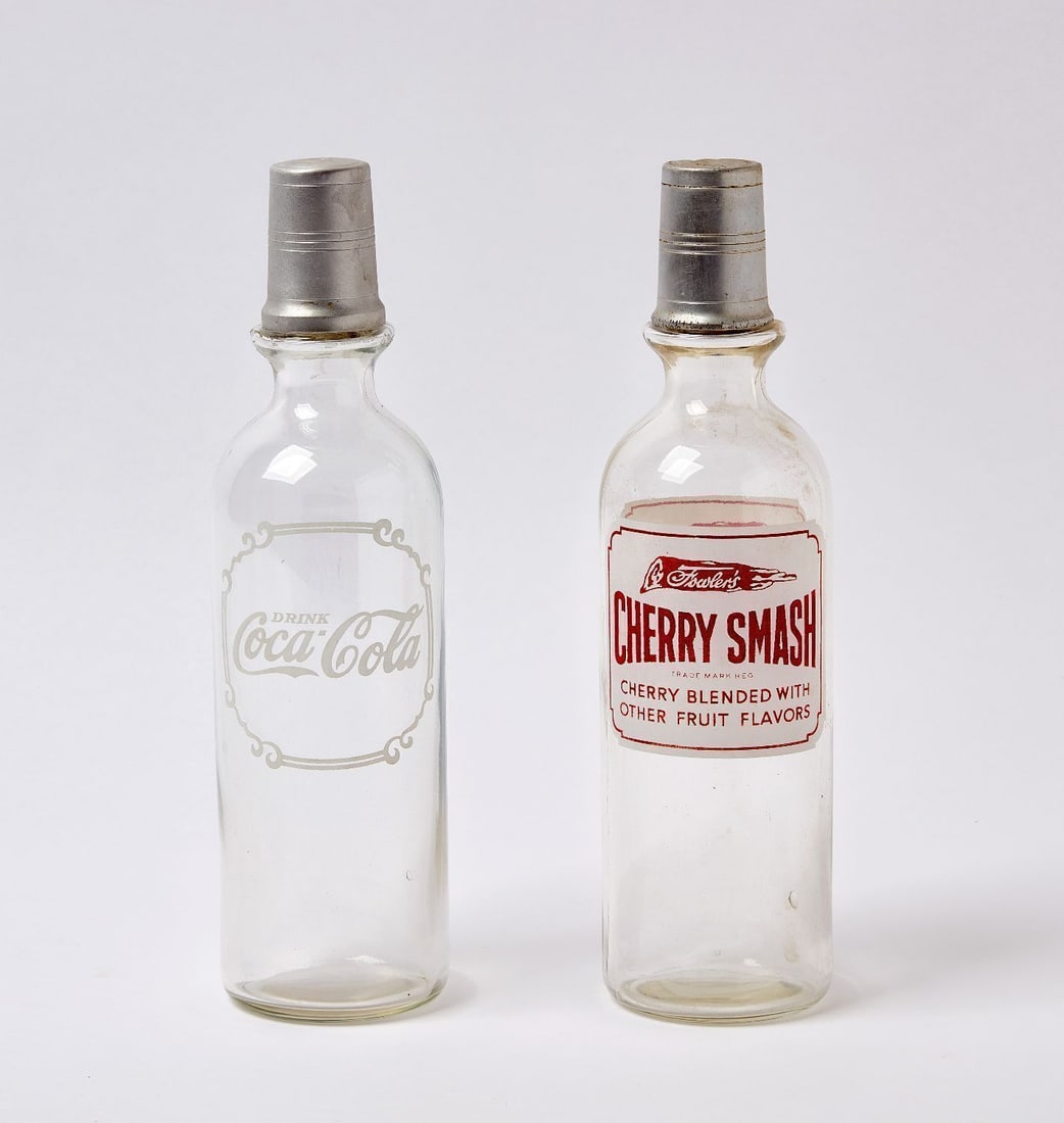 Two Barback Syrup Bottles - Coca Cola and Cherry Smash: Two early barback syrup bottles with original toppers. Coca Cola and Cherry Smash. Glass. American, circa 1920. Ea: H 12-3/8 in. Provenance: Collection of Paul and Dodi Algiers (Massachusetts, USA).