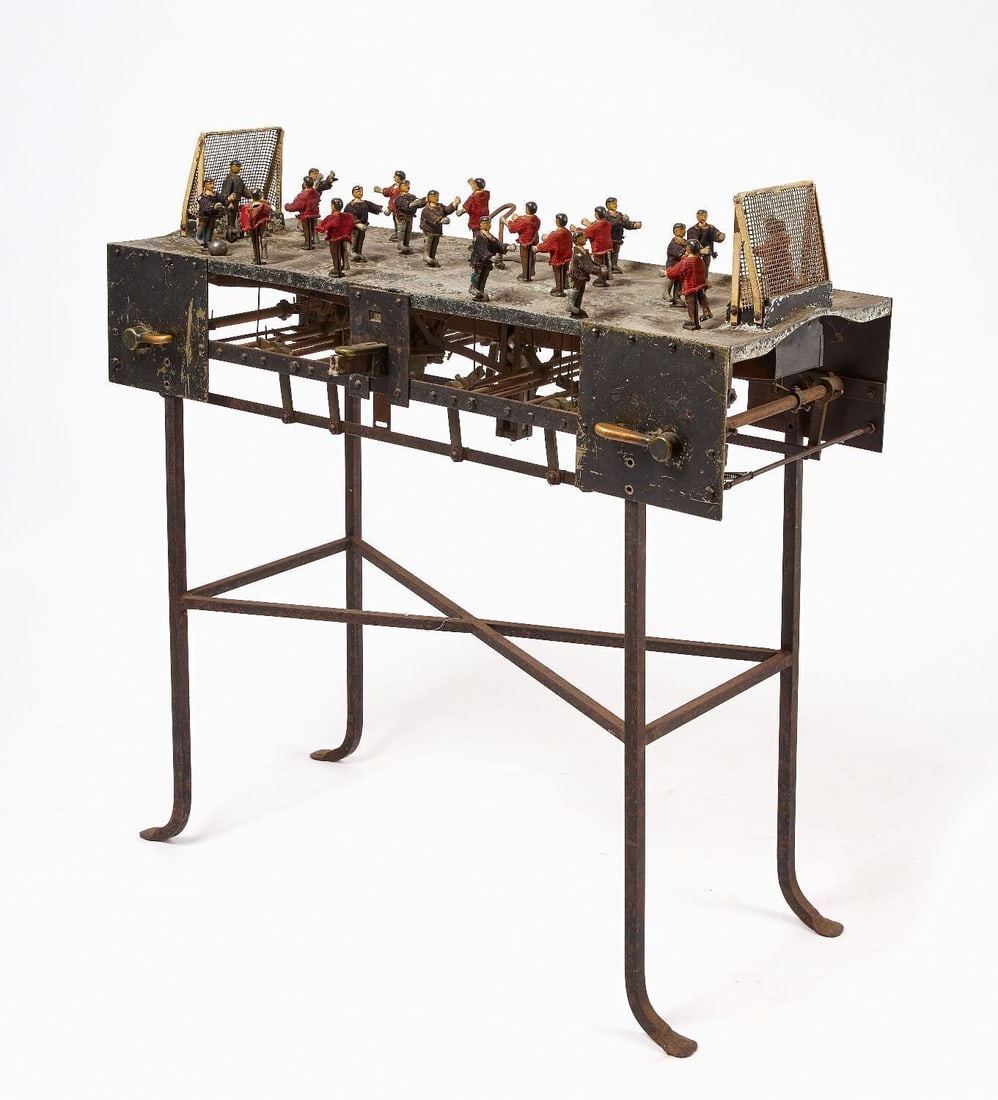 Foosball Table: Early Foosball table with metal players. 1 cent operation. Sits on iron stand. American, Circa 1910. H 41 in. W 41 in. D 16 in.