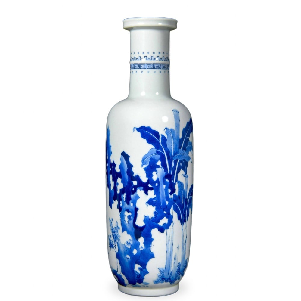 KANGXI BLUE AND WHITE 'BANANA PLANTS AND GARDEN ROCKS' ROULEAU VASE: Kangxi Blue and White 'Banana Plants and Garden Rocks' Rouleau Vase Dimensions: H: 12 5/8 in (32 cm); W: 3 1/2 in (9 cm) This stately rouleau (bangchui ping or 'mallet') vase is among the most iconic 
