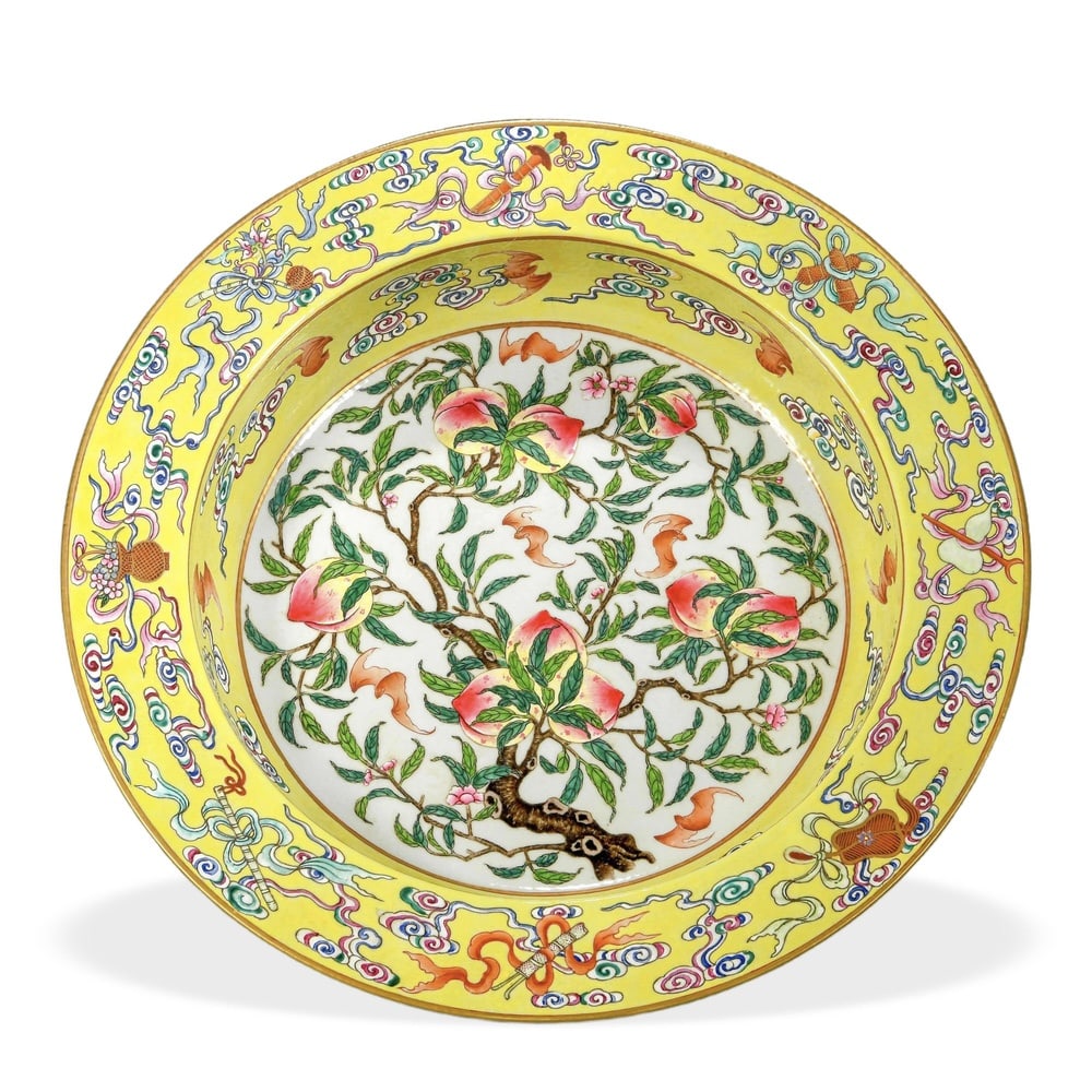 QIANLONG FAMILLE ROSE 'NINE PEACHES AND EIGHT DAOIST EMBLEMS' BASIN ON YELLOW GROUND: Qianlong Famille Rose 'Nine Peaches and Eight Daoist Emblems' Basin on Yellow Ground Dimensions: H: 3 1/2 in (9 cm); D: 16 in (40.5 cm) This generously proportioned basin (pankou pen) is among the mos