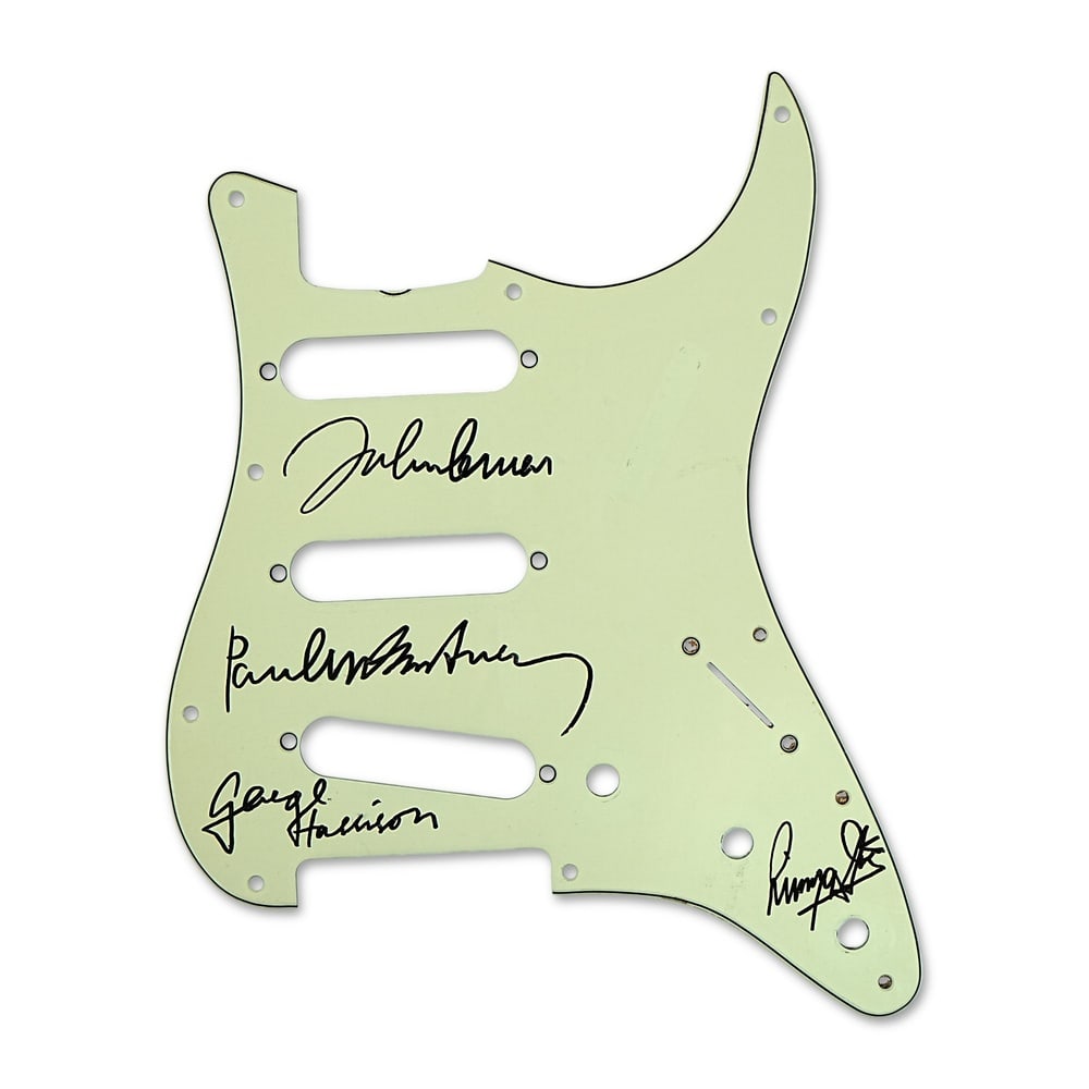 THE BEATLES FULLY SIGNED FENDER STRATOCASTER GUITAR PICKGUARD: 11 x 8 5/8 in (28 x 22 cm) Few signatures in popular culture carry the historical significance of The Beatles. This remarkable Fender Stratocaster-style guitar pickguard bears the signatures of all fo