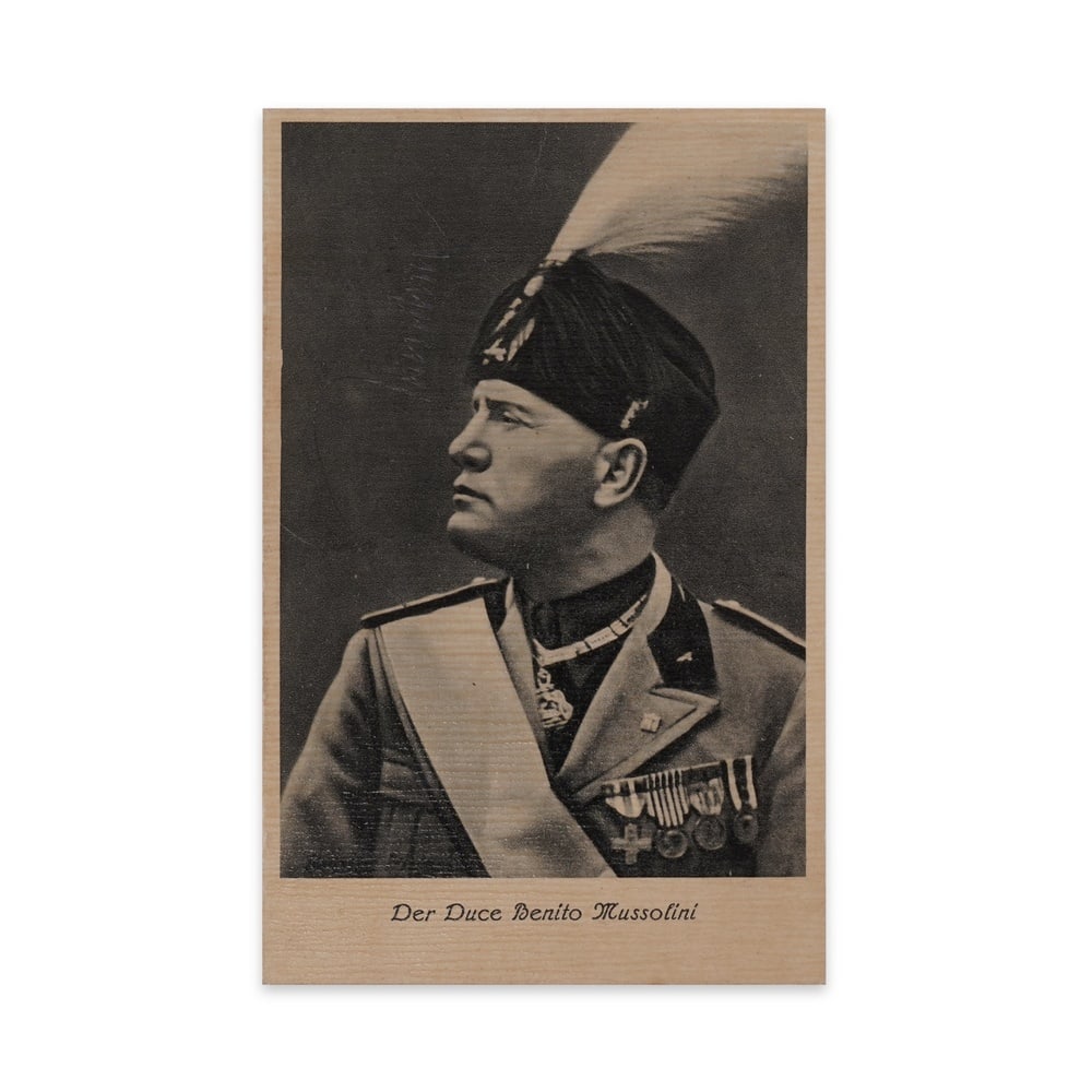 BENITO MUSSOLINI SIGNED PHOTO POSTCARD (1937): 5 1/2 x 3 1/2 in (14 x 9 cm) This historic German-issued postcard from 1937 features a bold black-and-white portrait of Benito Mussolini, the fascist leader of Italy, depicted in full military regalia