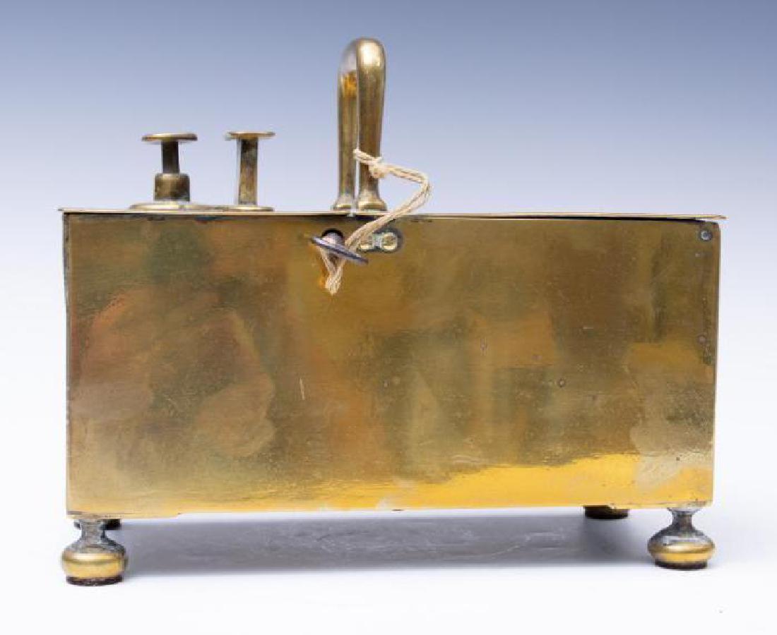 An English Brass Money Box, 18thc.: On bun feet, with key, locking mechanism and push button. 8 in. h. x 9.5 . in. l. x 5 in. d. Condition: As expected with wear and use