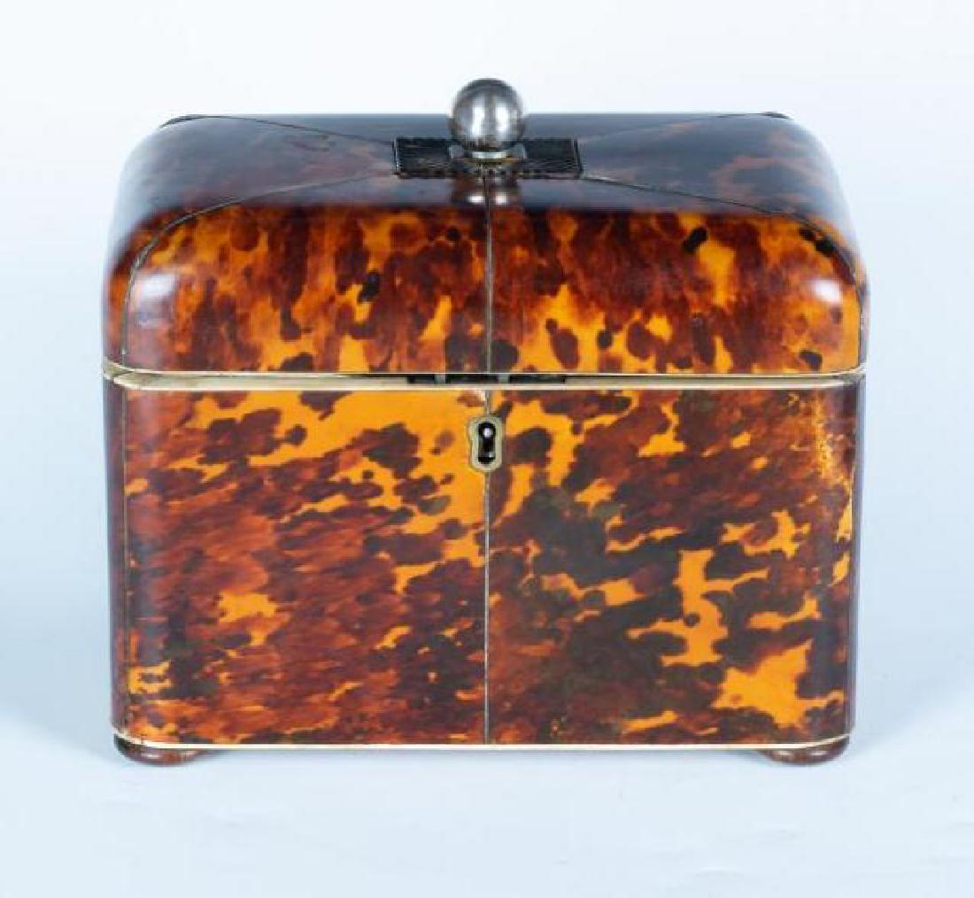 Antique Tortoise Shell Regency Period Tea Caddy: Veneered shell with bone edge and knobs on two interiors lids, Silver papered interior, with lock, no key. Rounded hinged lid with silver plate ball finial. Four wood bun feet. English c. 1820. Privat