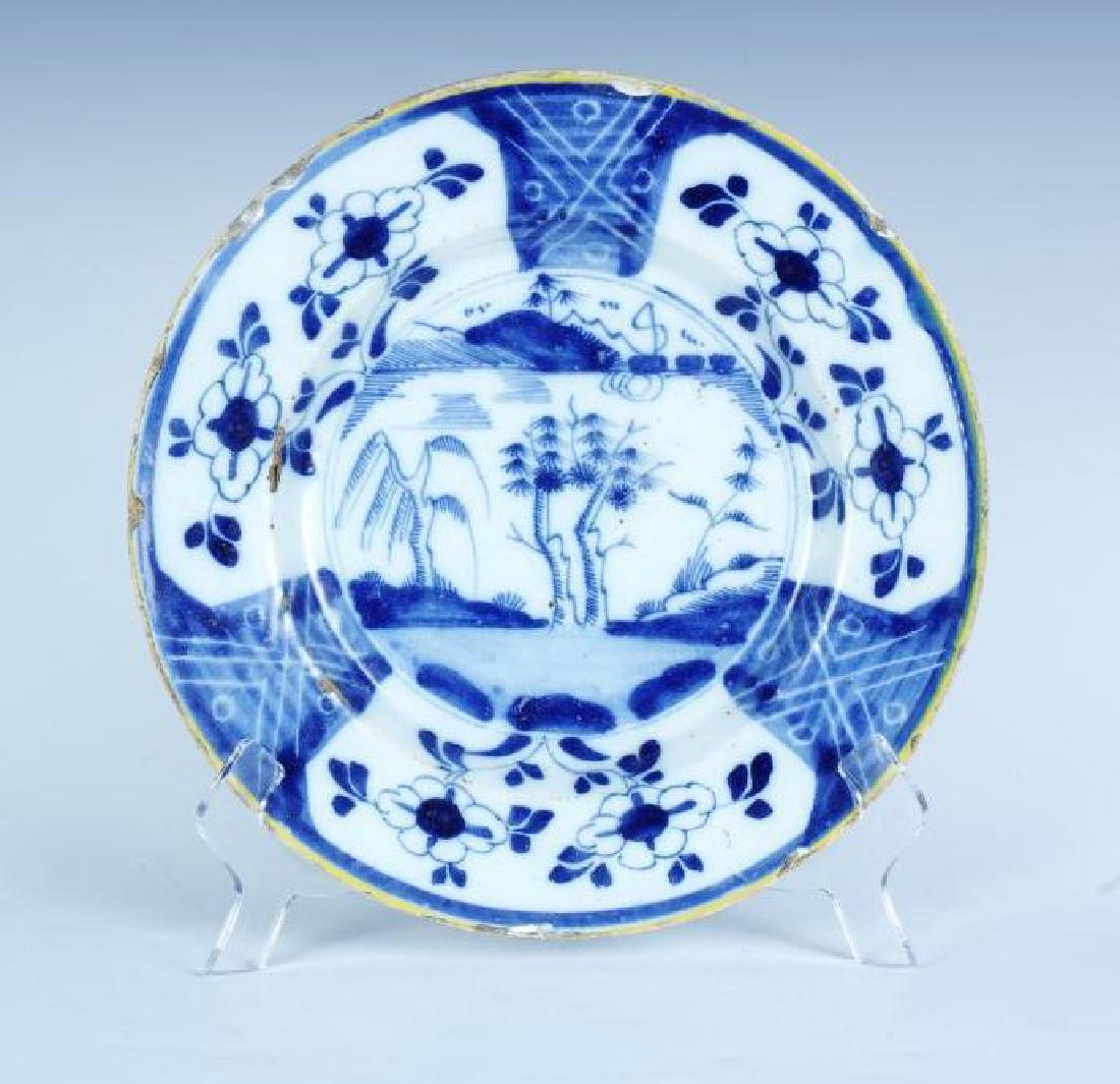 Delft Blue and White Plate: Earthenware dinner plate with blue and white enamel, yellow trim on edge, pictorial center with landscape, decorative broad border, unmarked, with many chips and losses, good, 10 in. diameter.