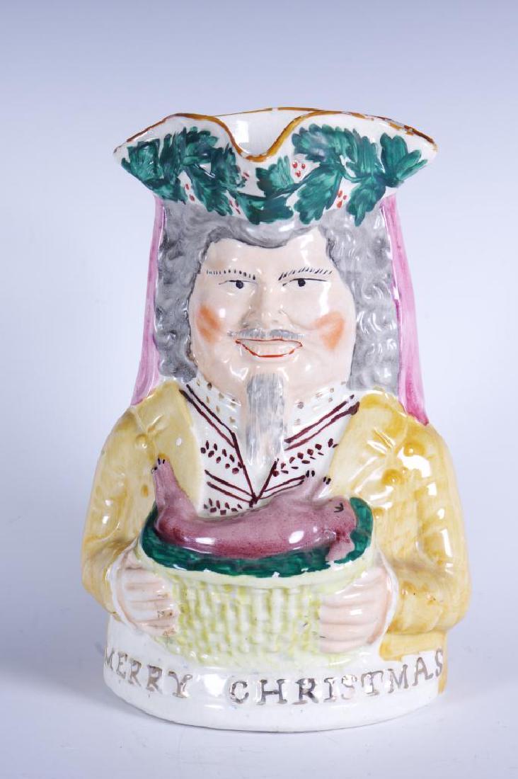 Staffordshire Merry Christmas Character Jug in Yellow: Figural toby character jug with man wearing yellow coat holding a holly rabitt for dinner. "Merry Christmas" in raised gilt decoration along the front of base, c. 1860. Unmarked, chips to gl