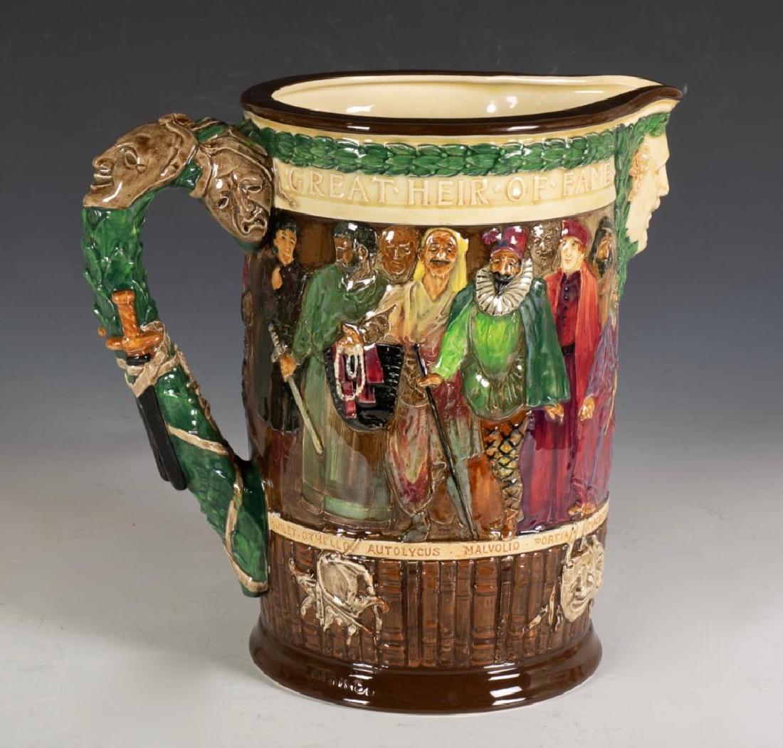 Royal Doulton Shakespeare Jug: The cylindrical form decorated in low to high relief with named characters from the plays, the handle decorated with theatrical masks, with mask spout, signed and numbered 323 from an edition of 1000.