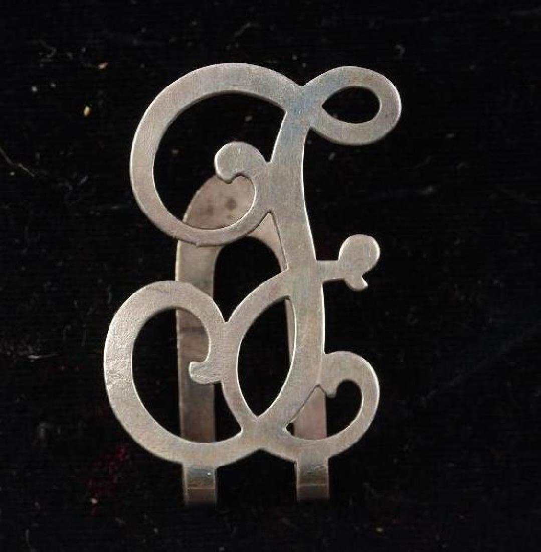 Sterling Silver Clip and Two Thimbles: Sterling money clip with an ornate F initial, hallmark visible on the back. 1.75 x 1.25 in. .309 oz. troy Condition: Some light tarnishing and a few scratches. Pair of sterling silver thimbles with te