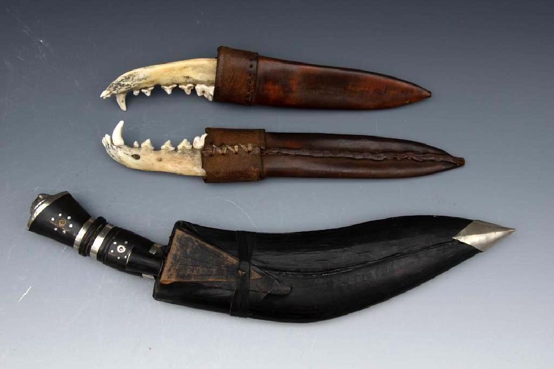 Three Sheathed Gives, Two of Jaw Bone: Three sheathed gives, or daggers, two made of jaw bone with attached teeth, each measuring 10 in. in length. The third is a longer curved blade with small attachable piece and a geometric design on to