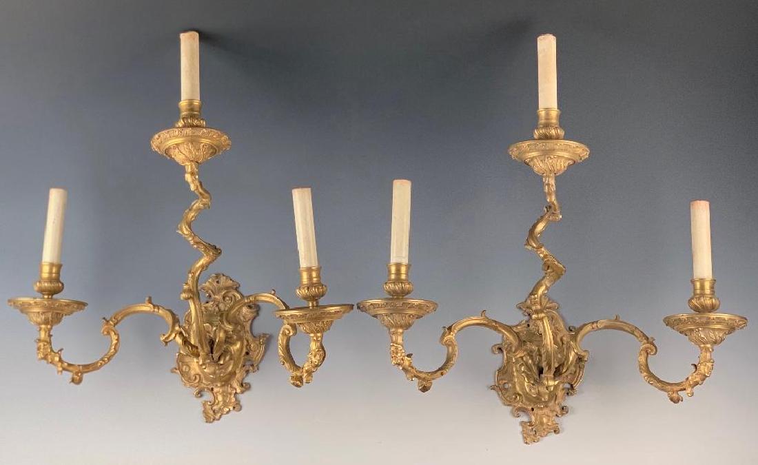 A Fine Pair of French Rococo Bronze Dore Wall Sconces: c. 1790-1800, the backplates cast in the form of a mask, the mouth issuing 3 foliate scroll armatures, the two outer arms cast with male and female terms. 23 in. h x 20 in. w. x 12.5 in depth