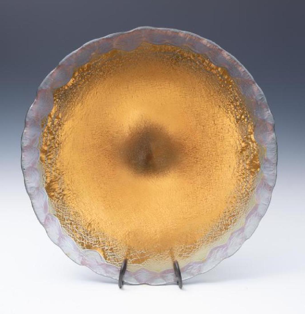 Large Glass Charger Signed Salvador Rossi: Large heavy charger form in gold iridescent glass with clear edge. Signed on rim 22 in.dia. Condition good with no damage or repair