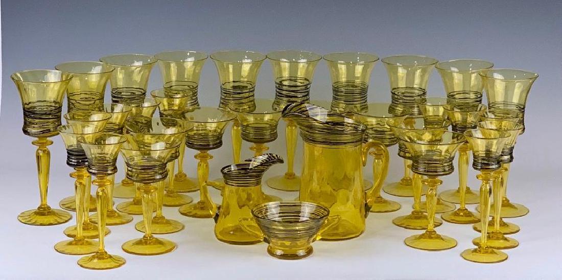 Steuben Black Threaded Bristol Yellow Service: Comprising 10 water goblets, 8 wines, 10 sherry glasses, sugar bowl with applied handles, creamer and water jug. 9.25 in.h. tallest. Acid stamped signature. Condition: 