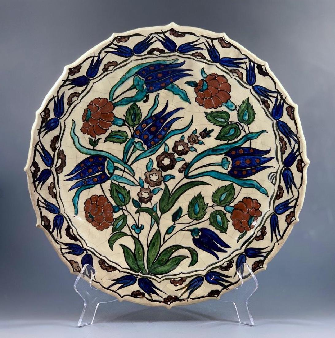 Edmond Lachenal Iznick Style Faience Charger, 1900: Edmond Lachenal (French 1855-1948) Scalloped form on rimmed foot, decorated in Persian style with flowers and seed pods on foliate stems on a crazed off white ground in blue, green, r
