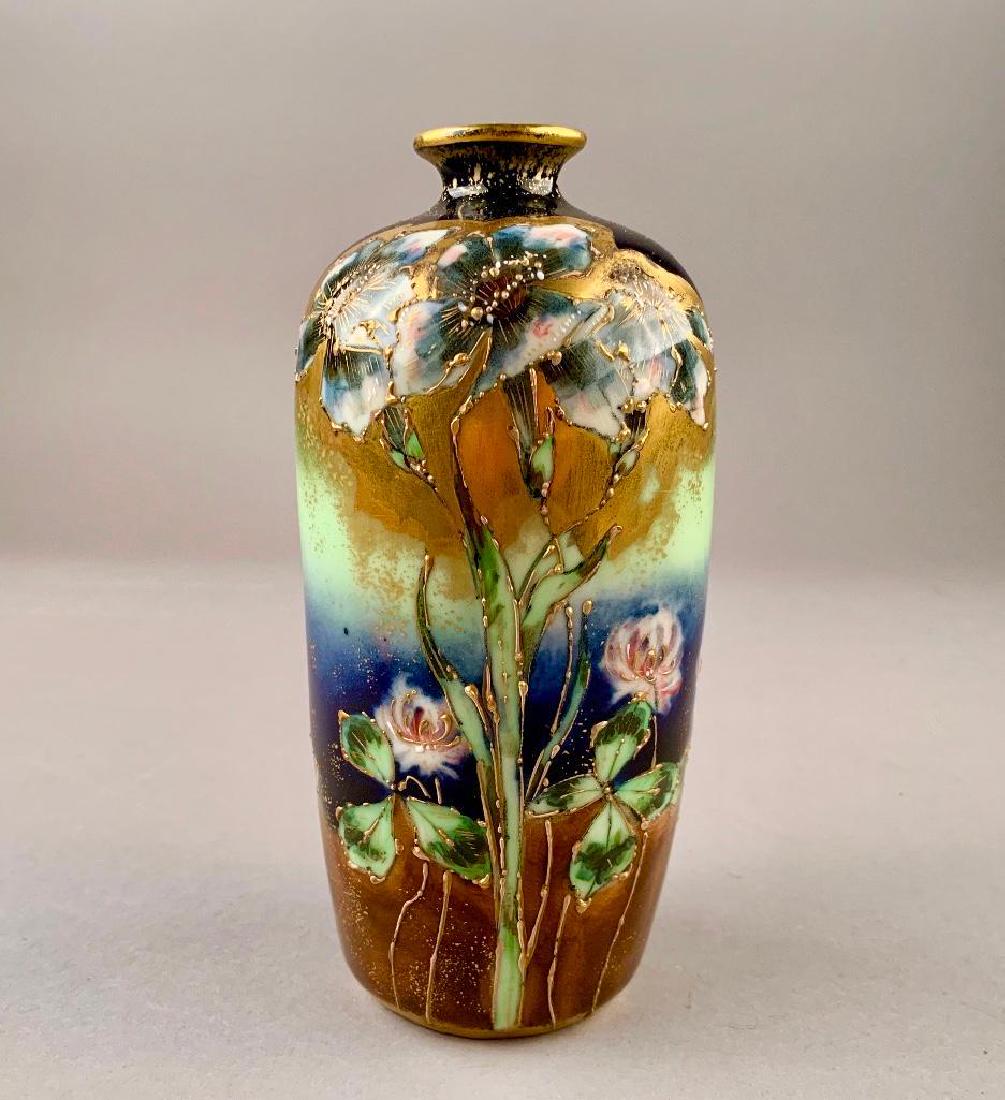 A Riessner Stellmacher and Kessel (Amphora) Cabinet: In Art Nouveau style, the baluster form decorated with open petaled flower forms and blooming clovers on tall stems reserved on a cobalt, paler green and brown ground, embellished with gilding. Signed
