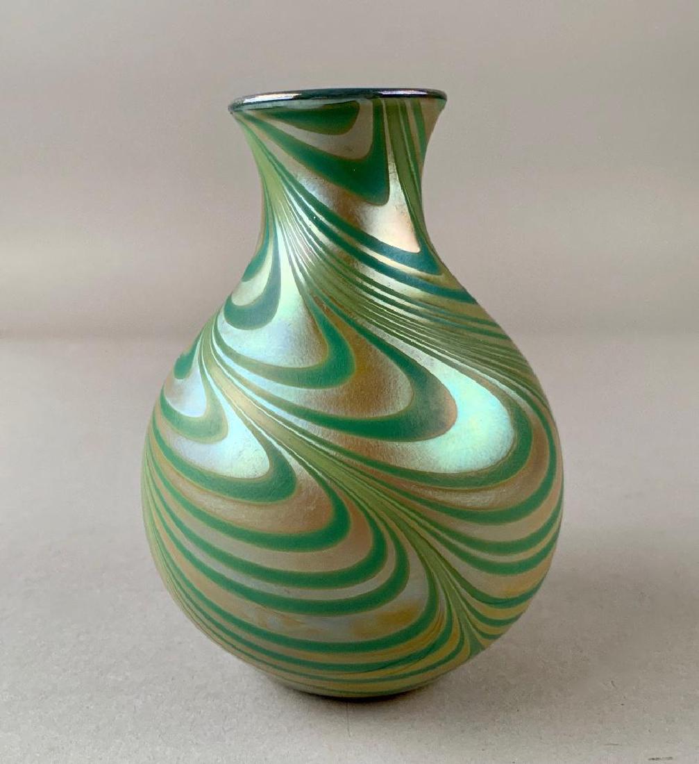 Charles Lotton Iridescent Glass Vase: Bottle form with everted rim in pulled and trailed iridescent green and gold glass, with opaque white cased interior. Signed and dated 1975. 5.75 in.h. Condtion: Good