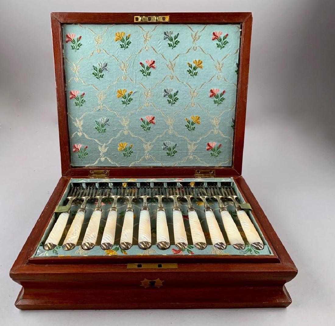 English Silver and Mother of Pearl Fruit Service: Service for 12, London, or Sheffield, 1896 ?, makers mark SP, in silver with mother of pearl twist handle, in two tiered fitted wood case with hinged cover and inlaid brass shield and escutcheon. Cond