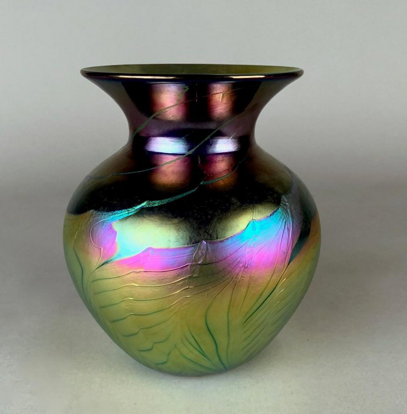 Lundberg Studios Art Glass Vase, 1999: Of baluster form with wide everted mouth, in iridescent gold, purple, blue and green glass with pulled and trailed decoration. Signed Lundberg Studios, dated 1999, and numbered 04121. 7 in.h. Conditio