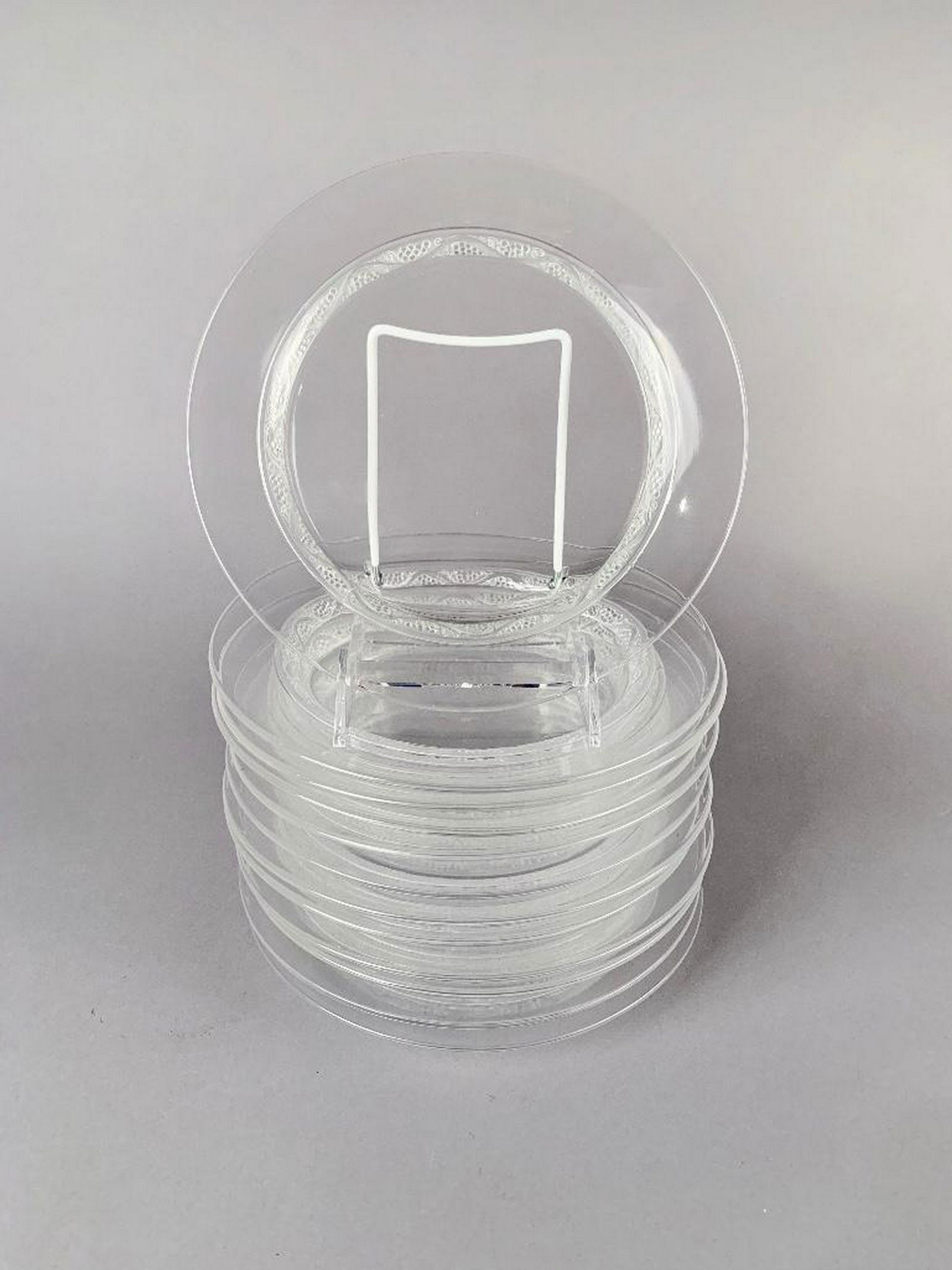 12 Lalique Crystal Plates: In clear and frosted glass molded with a grapevine pattern around the foot. Incised signature, Lalique France 8.5 in. dia. Condition: Very good, one plate with scratch, a few with small flakes to foot