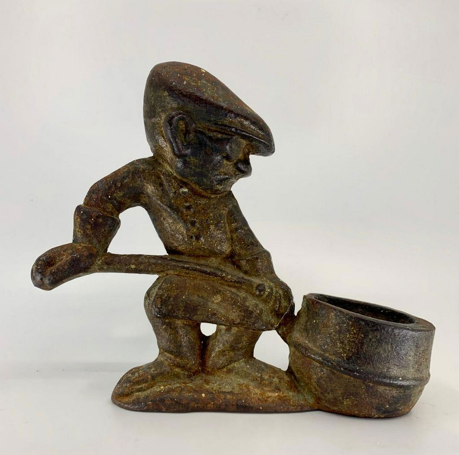 Cast Iron Doorstop: In the form of a steelworker with a ladle. 6.5 x 7.5 in. Condition: Slightly rusted and pitted as appropriate for age and use.