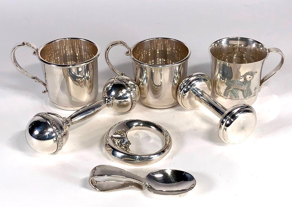 Assorted Sterling Silver Baby Items,Tiffany and Others: Assorted Sterling Silver Lot, Tiffany and Others, comprising a Tiffany baby mug with an embossed lamb, a Tiffany baby spoon and a Tiffany moon form rattle, together with a Schroth rattle and two Schro