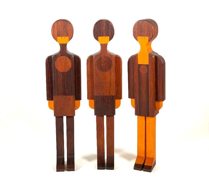 Three Charming Figural Wood Specimen Samples: Three Charming Figural Wood Specimen Samples, c.1960-70, each in the form of a standing stylized girl, one of walnut, padouk wood, and birch with ebony eyes, the second of walnut, English silver-grey