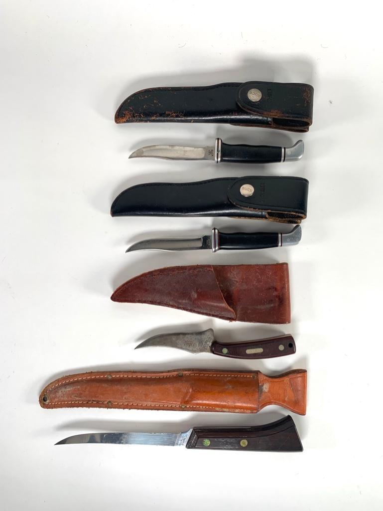 Four Vintage Buck, Fillet and Skinning Knives: Lot includes a Schrade "Old Timer" skinning knife with a 3.5 in. blade with a textured resin grip in custom leather sheath; two identical Buck, U.S.A. knives with black resin handle, 4 in. blade sta