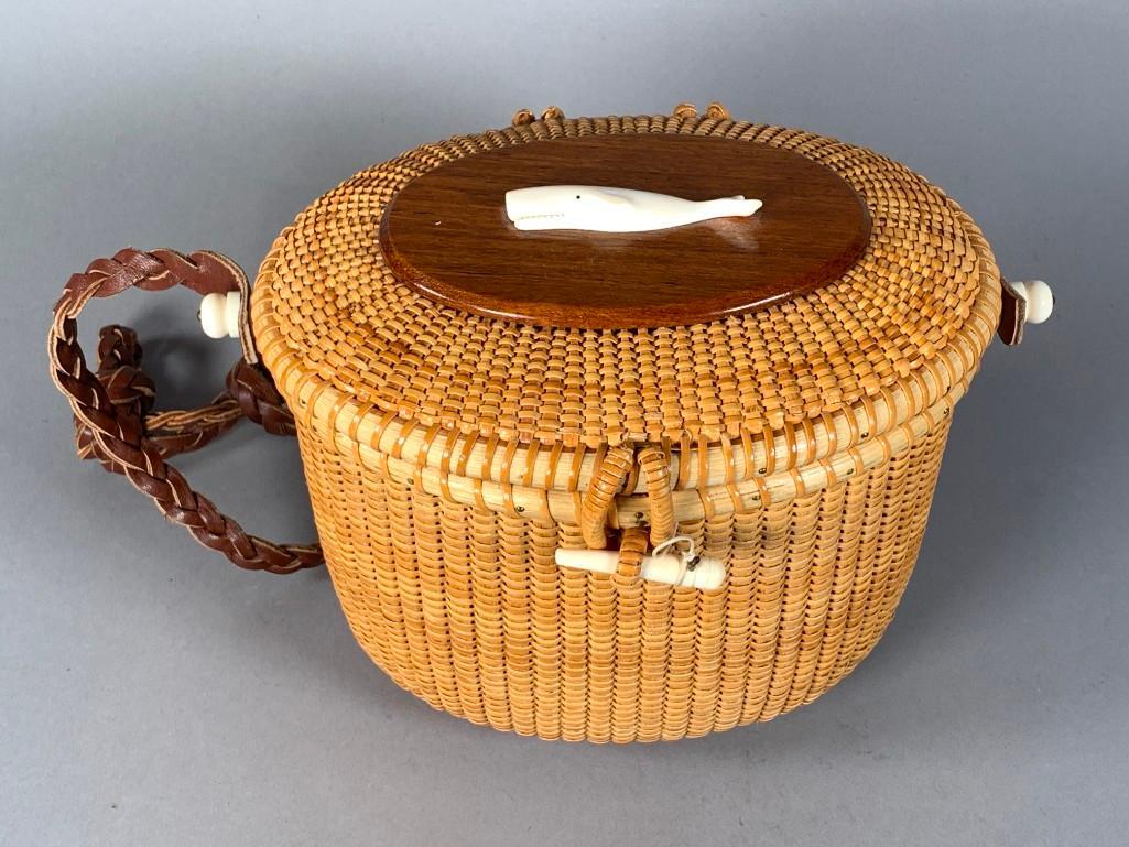 Terry Sylvia Nantucket Basket, 1995: Terry Sylvia Nantucket Basket, 1995, hand woven oval form with a carved whale on the hinged cover, with bone fittings and closure, with braided leather strap, signed Terry Sylvia, Nantucket Island, 19