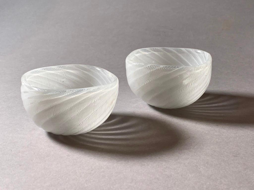 Pair of Venini Murano Blown Glass Bowls: Pair of Venini Murano Blown Glass Bowls by Carlo Scarpa, small handblown forms in a latticino ribbed twist pattern in clear glass with internal decoration in opaque white. Signed Venini Murano Italia 