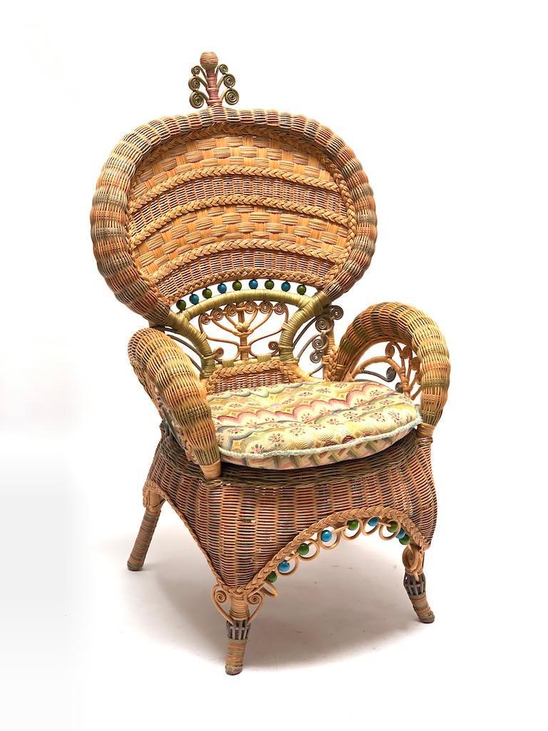 Mackenzie Childs Woven Wicker Chair: Mackenzie Childs Woven Wicker Chair, victorian style woven form with painted wood beads and upholstered cushion. Brass plaque signature. Dimensions: 48 x 27 x 23 in. Condition: Good with some light we