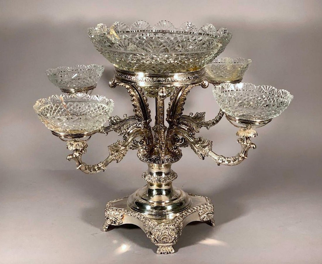 English Silver Plated Epergne, Late 19thc.: English Silver Plated Epergne, Late 19thc, squared base on scroll feet, the shaped standard with four scrolled arms supporting cut glass bowls, with four Prince of Wales plumes supporting a center cut