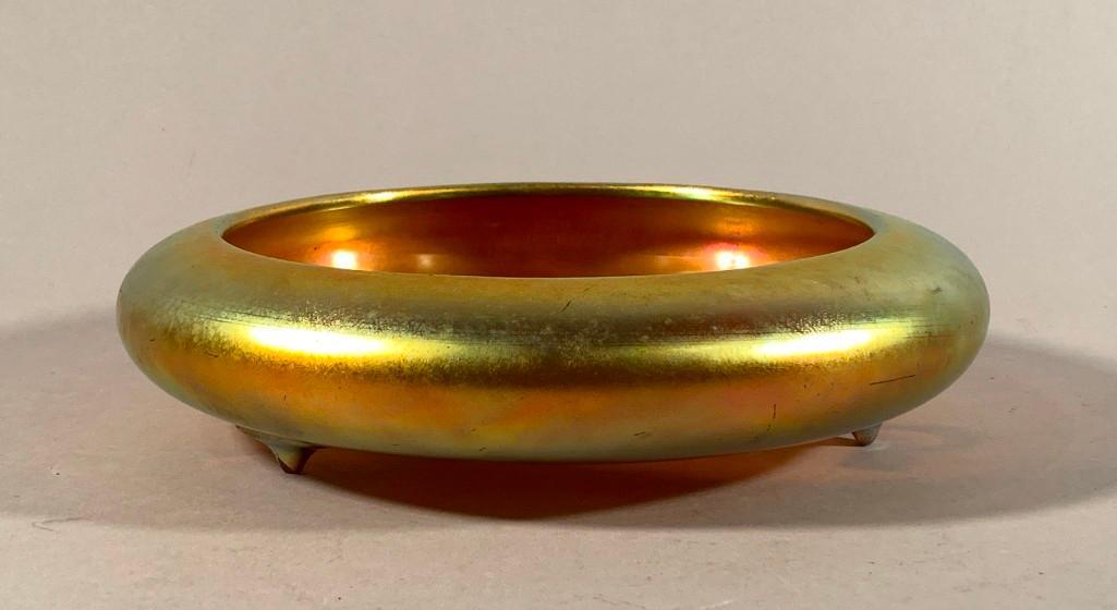 Steuben Gold Aurene Center Bowl: Steuben Gold Aurene Center Bowl, circular low bowl form on tripod teardrop feet, iridescent gold Aurene glass, signed Aurene and numbered 2586. Dimensions: 10.25 in. dia, 2.5 in.h. Condition: Some wea