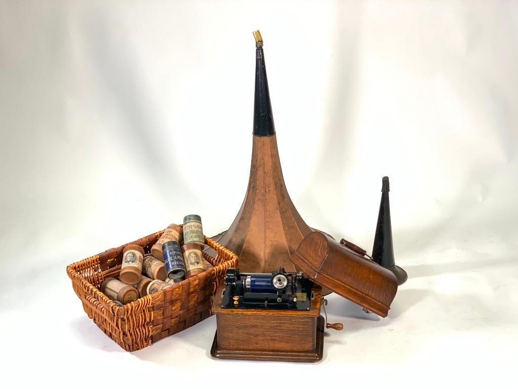 Edison Standard Wax Cylinder Player Phonograph: Golden oak case with humpback lid, with large horn, needle and a basket full of wax cylinders. Size Closed with lid 11.5"T x 11"W x 7.5"D. Large megaphone is 32"T, the smaller horn is 15"T. Condition:
