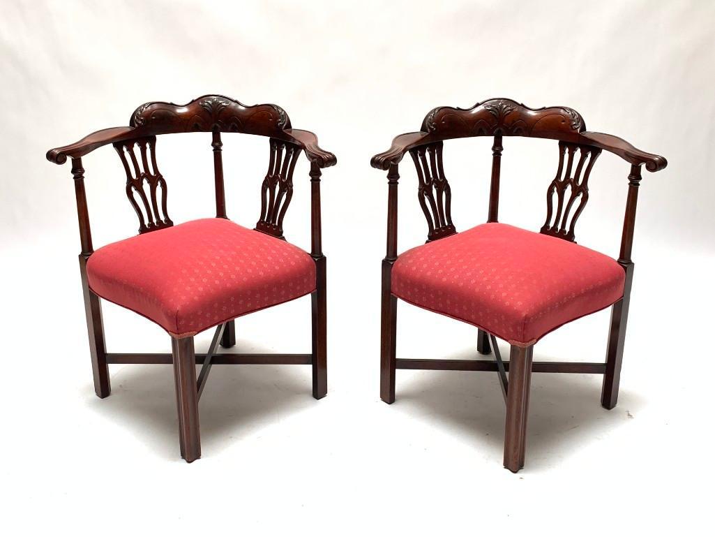 Pair of English Mahogany Chairs, 19th Century: Carved mahogany matching corner chairs with upholstered seat cushions. Crest rail carved with acanthus leaves, two open-worked spats support the armrests which terminate in a scroll. The chairs have t