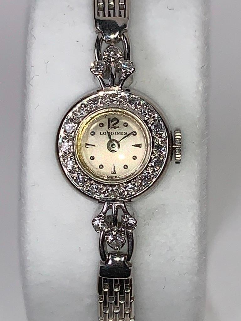 14K White Gold and Diamond Ladies Longines Bracelet: 14K White Gold and Diamond Ladies Swiss made Longines Bracelet Watch, round case diamond bezel with pave single cut diamonds, warm matte finish dial with Arabic numerals at 12 with hour markers, wove 