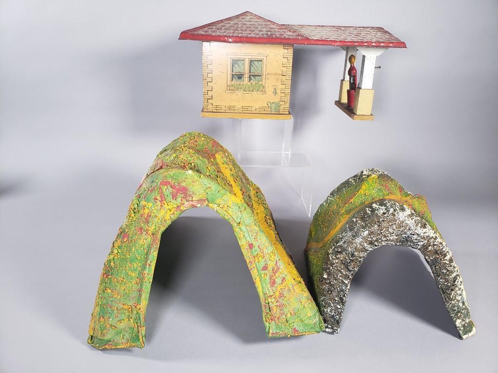 Vintage Gibbs Gas Station and Two Mountain Tunnels: Vintage Gibbs Pressed Steel Single Pump Gas Station, c.1926, and Two Fiberglass and paint decorated train set Mountain Tunnels. Dimensions: Gibbs, 5 x 15 x 9 in. 9 x 10 in. larger mountain Condition: