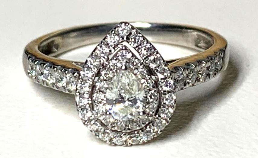 White Gold and Diamond Ring: White Gold and Diamond Ring, pear shaped diamond approximately .75 carat in conforming stepped setting with small round cut diamonds. Unmarked. Approximate total weight 2.64 g. Approximate ring size 5